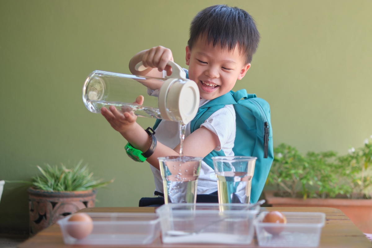 Boy experimenting with water and eggs