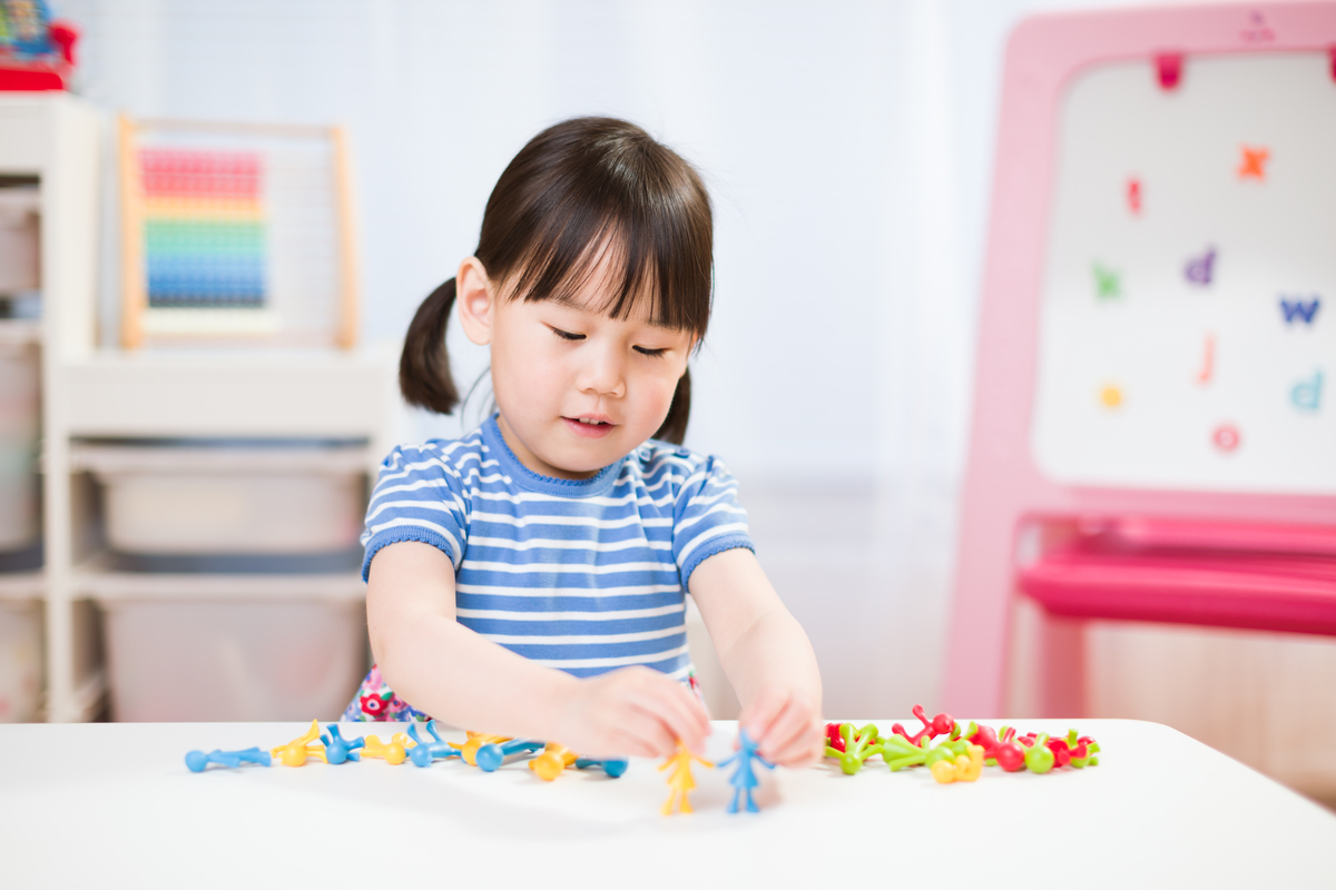 young girl playing with figurine toys