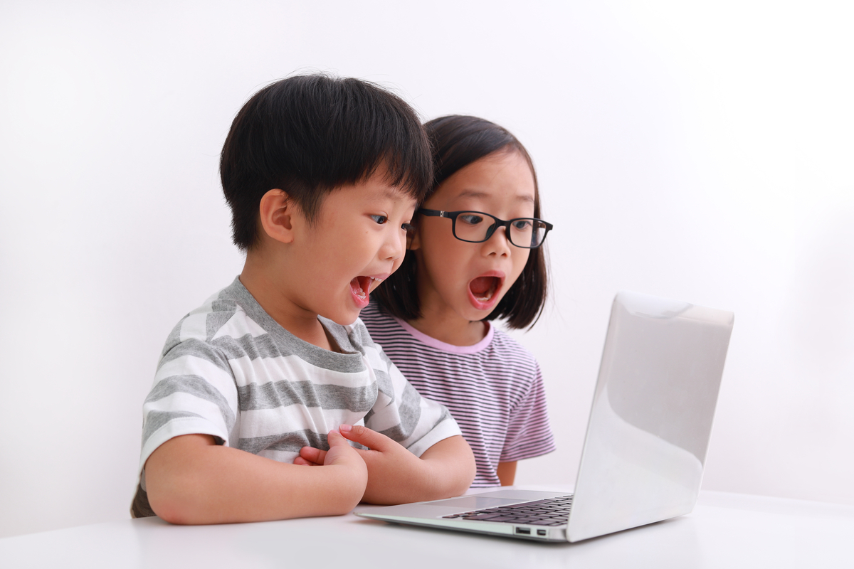 two children using laptop with surprised expression