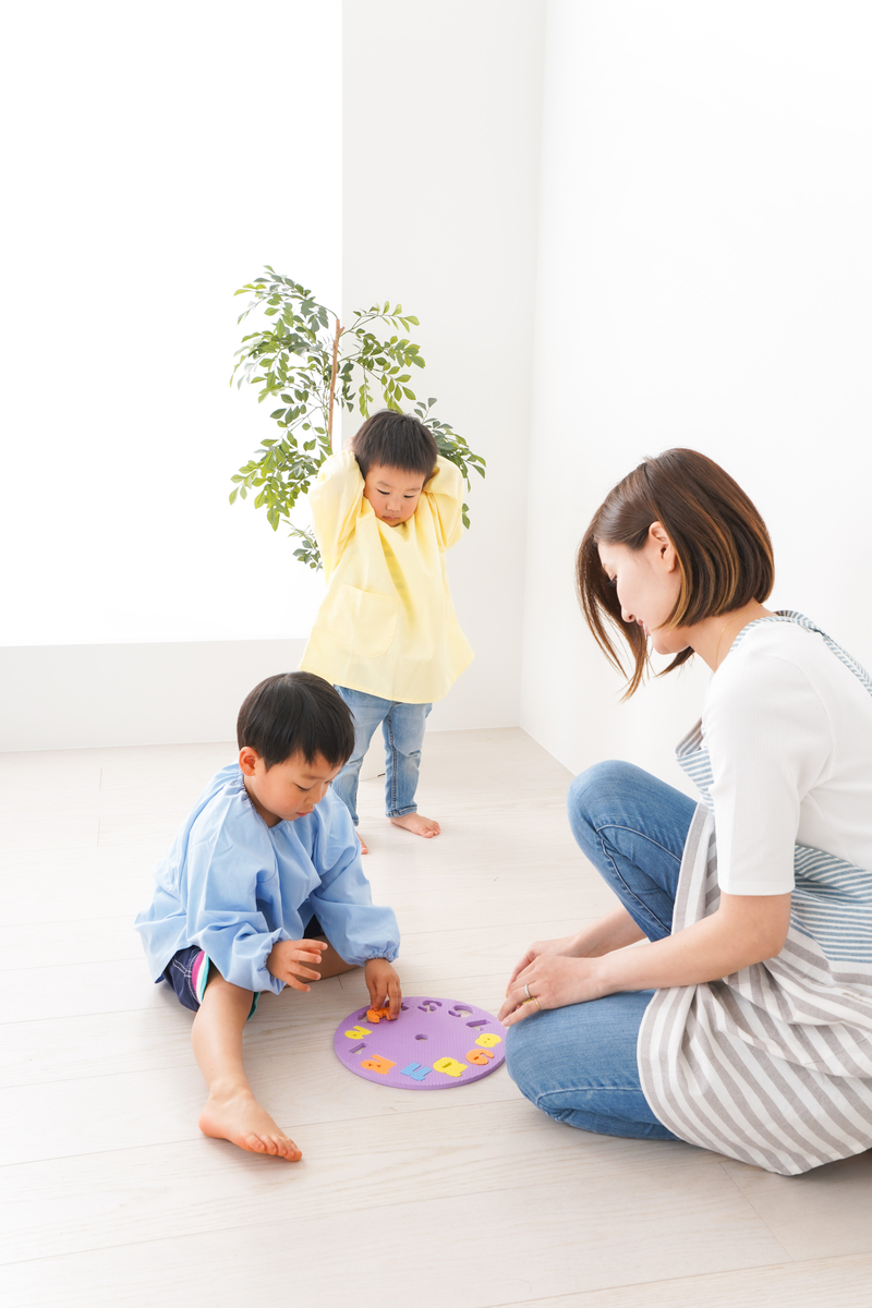 Children in kindergarten trying out activity with teacher