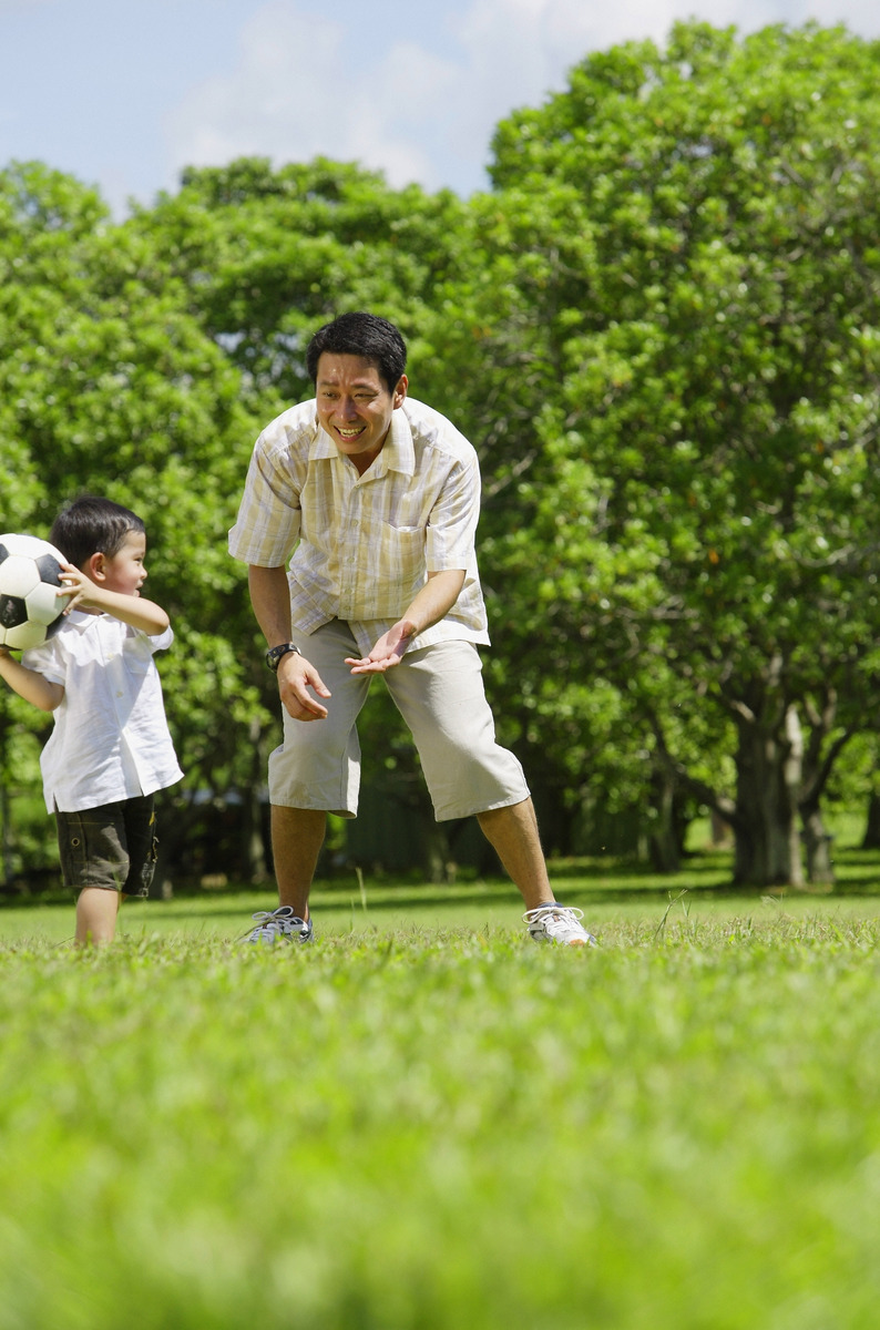 Father and son playing soccer