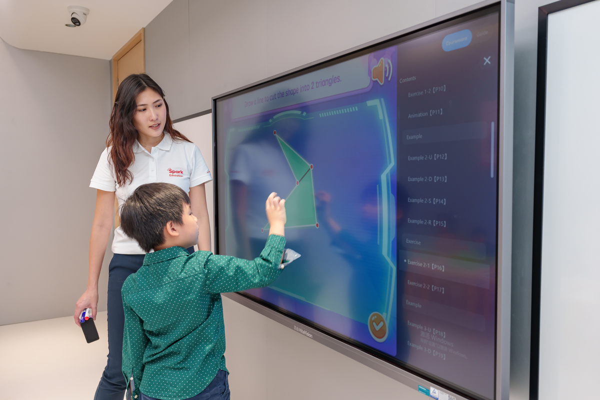 Student trying out the interactive screen with teacher's guidance