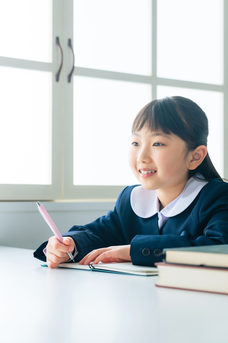 girl with pen in hand and books at her side