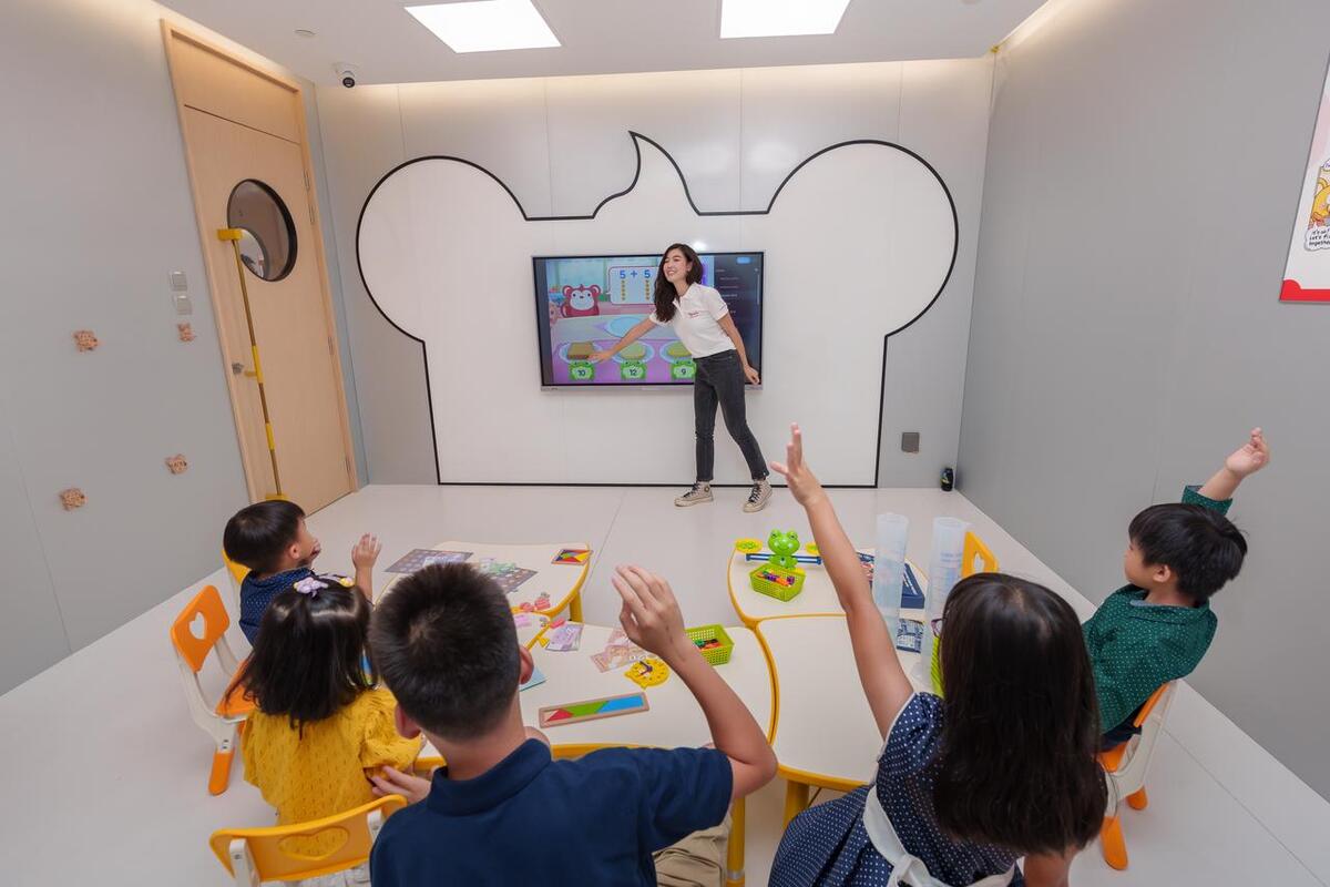 Teacher using interactive screen and students participating in high-tech classroom