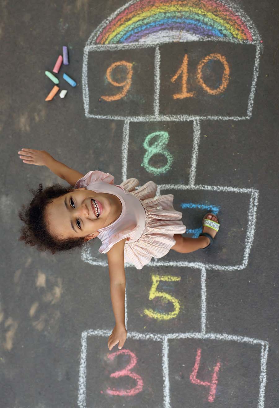 What Is Numeracy? Littl girl playing hopscotch Smiling
