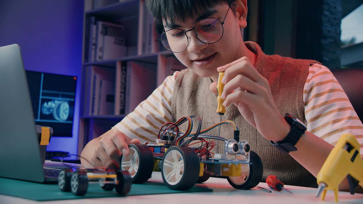 celebrate International STEM Day Kid working ona robot car