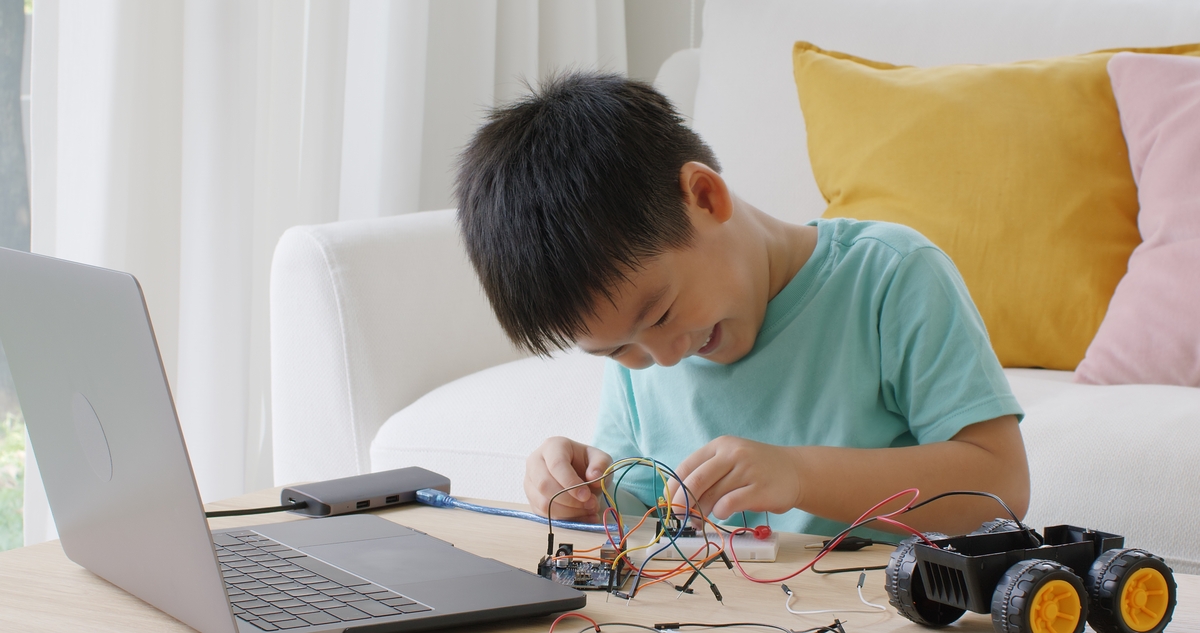 Celebrate International STEM Day boy building a robot