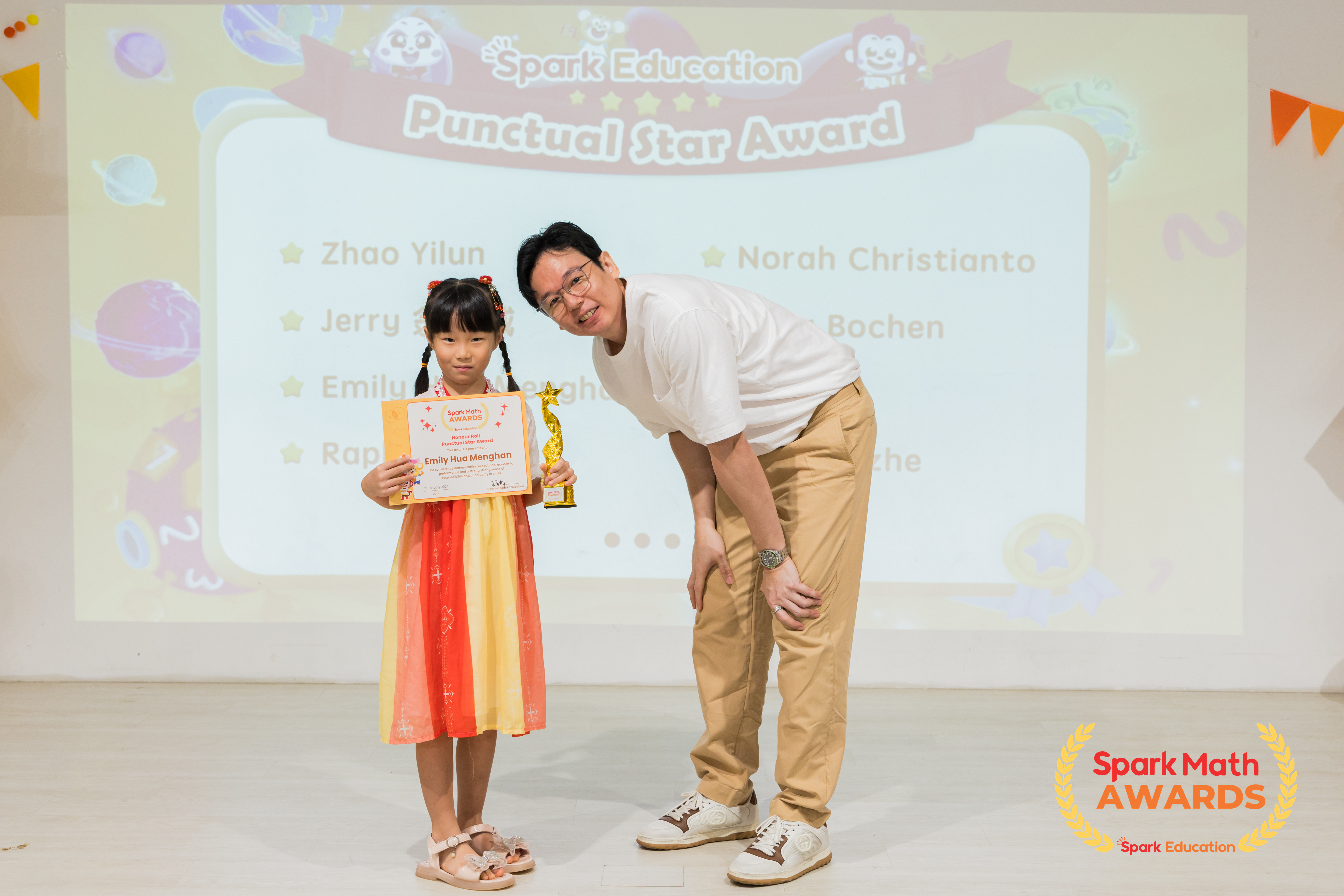Teacher Roy, Upper Primary Curriculum Specialist, presenting the Honour Roll and Punctual Star awards to top performing Spark Math winners who have shown a great sense of responsibility and punctuality in all their learning activities.
